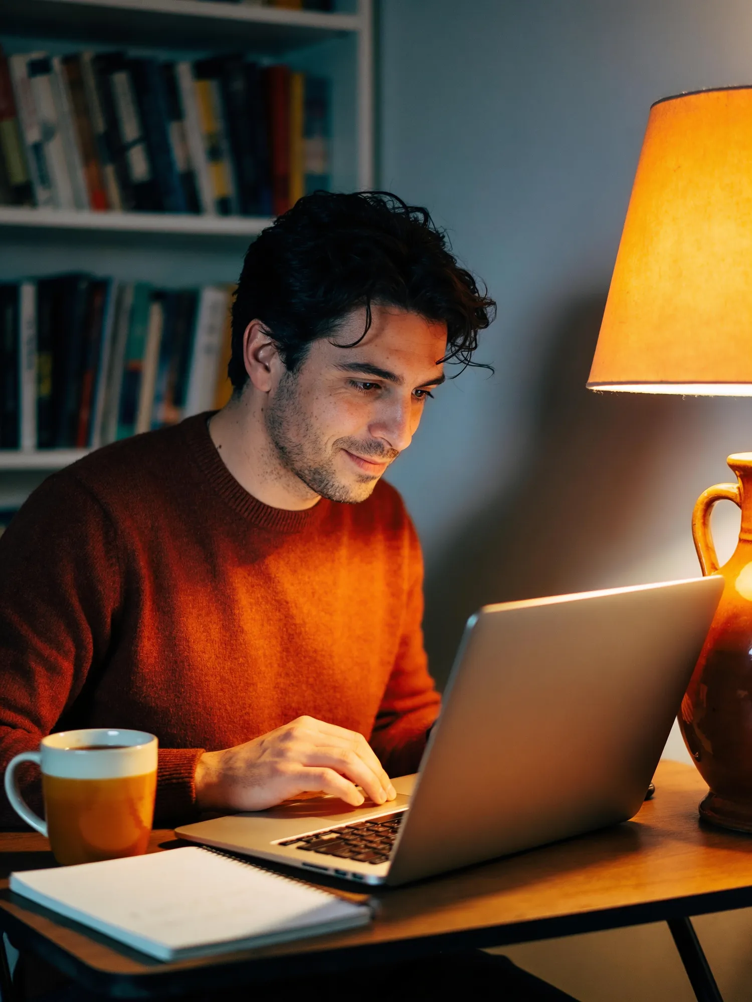 Un uomo a casa, al computer, prepara la ricerca del nuovo lavoro